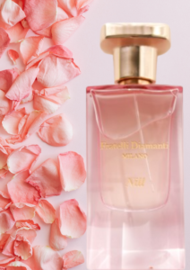 Elegant pink perfume bottle with a gold cap surrounded by soft pink rose petals