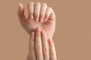 Well-manicured natural nails with soft pink polish, showcasing a clean and elegant nail-care look.