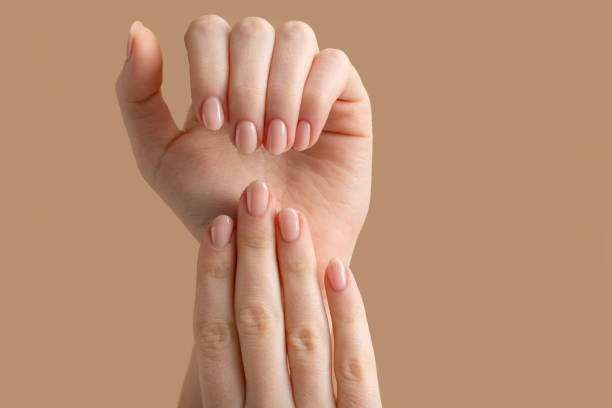 Well-manicured natural nails with soft pink polish, showcasing a clean and elegant nail-care look.