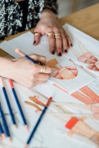 Fashion designer sketching clothing designs and outfit ideas on paper