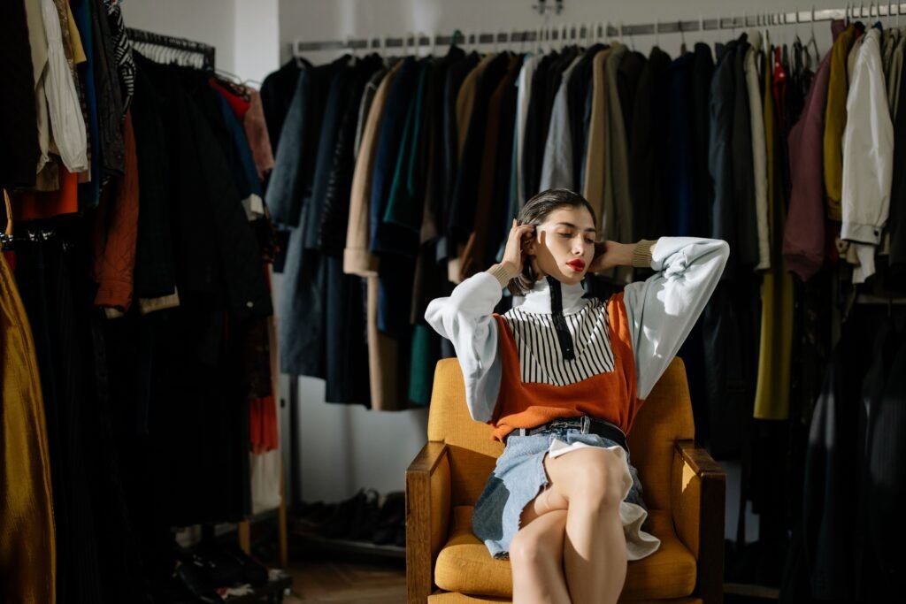 Woman choosing an outfit while surrounded by clothes in a stylish wardrobe