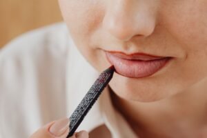 Woman applying lip liner for a natural 2026 ombré lip makeup look