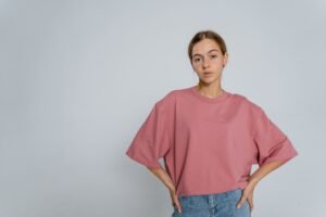 Woman wearing an oversized pink T-shirt with blue jeans, casual fashion style