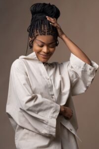 Woman wearing a relaxed neutral linen shirt with braided hair in a stylish everyday fashion look