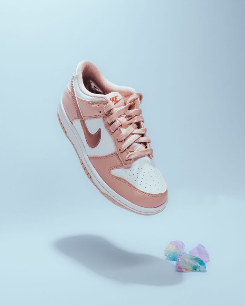 Pink and white Nike sneaker with modern design, showcasing popular footwear brands style