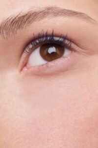 Close-up of a brown eye with blue mascara and natural eyebrow makeup