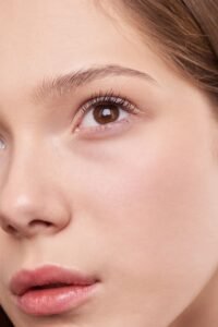 2026 makeup trends featuring soft natural skin, rosy blush, defined lashes, and glossy pink lips