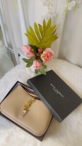 Beige Saint Laurent designer handbag with gold logo and luxury gift box