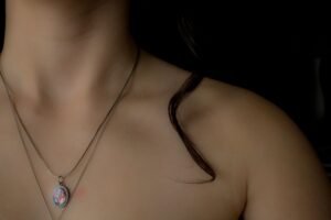 Elegant oval pendant necklace with colorful gemstone detail on a layered silver chain