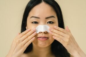 Woman using a pore pad on her nose as part of a Korean skincare routine for clean and smooth-looking skin